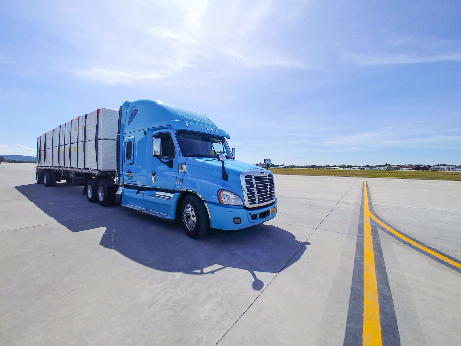 JRC Transportation flatbed truck loaded with building materials